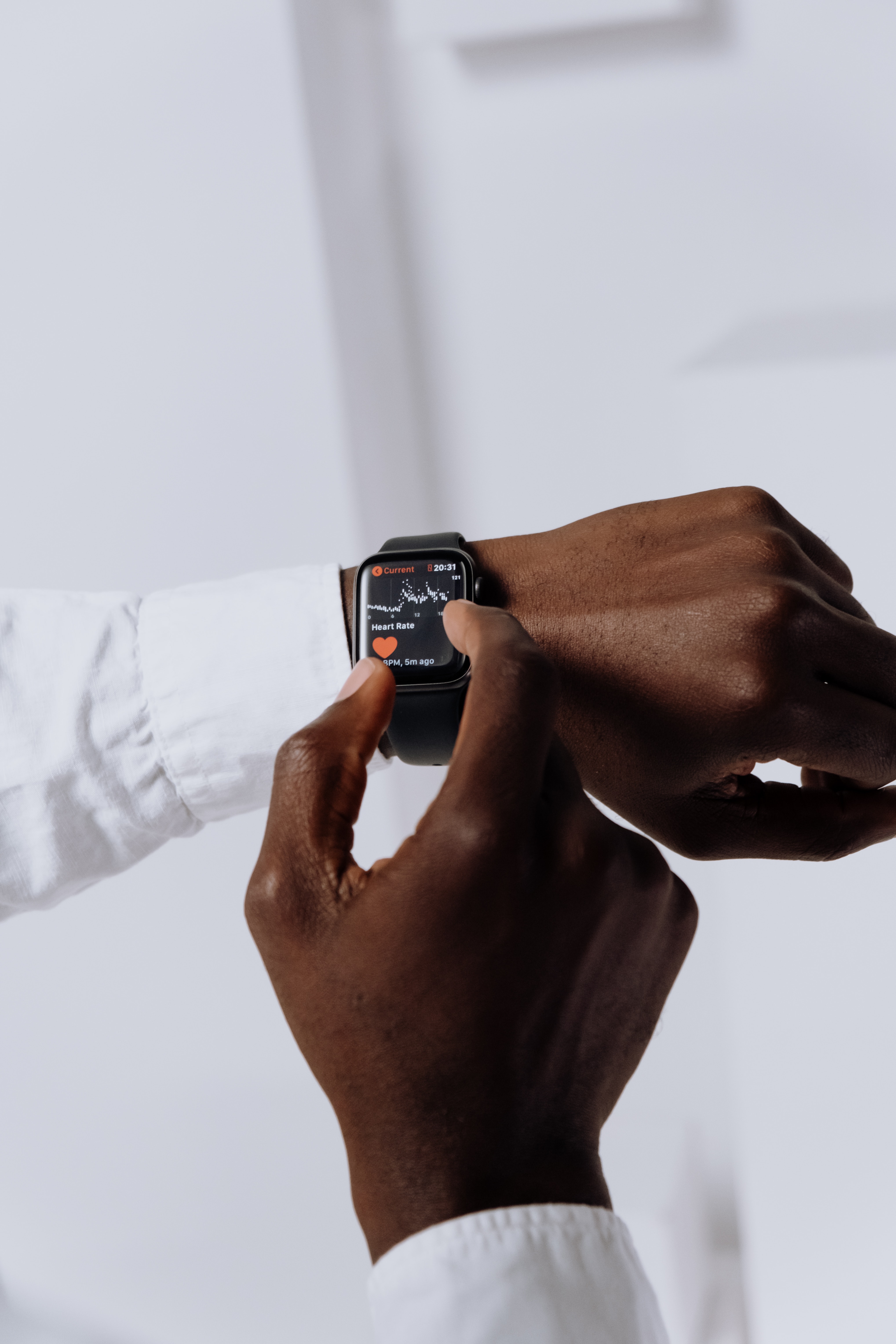 Apple Watch on a wrist showing the heart rate